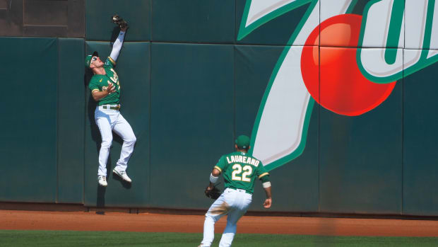 Mark Canha skies up against the wall in left-center to make a catch some compare to Joe Rudi's in the 1972 World Series.